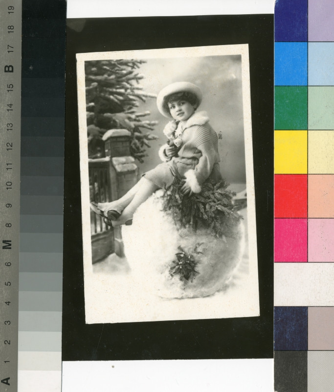 neurčený autor - Děvčátko, sedící na sněhové kouli, drží jehl. větev a růži